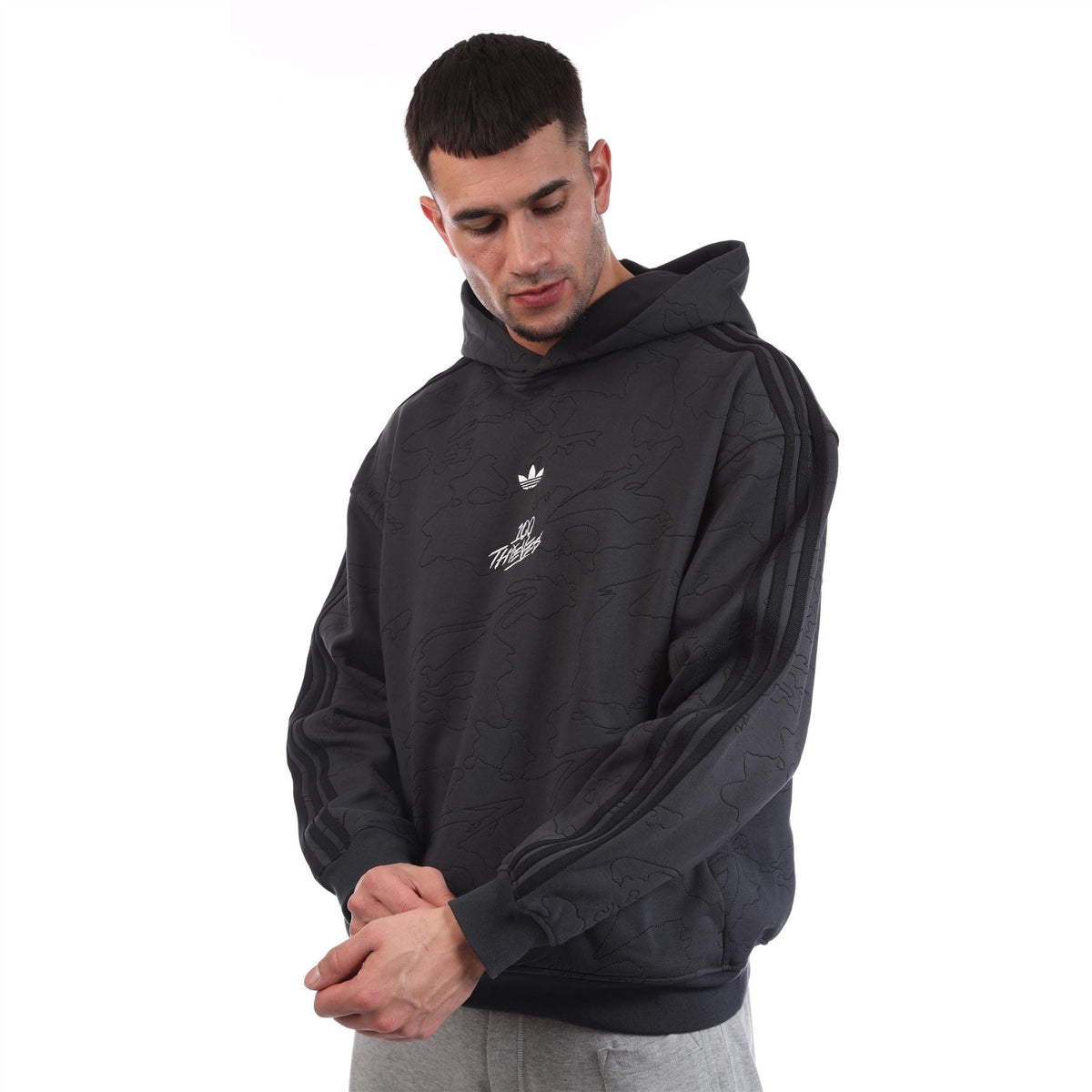 Black pullover hoodie with hood, front logo print, and striped sleeve panel