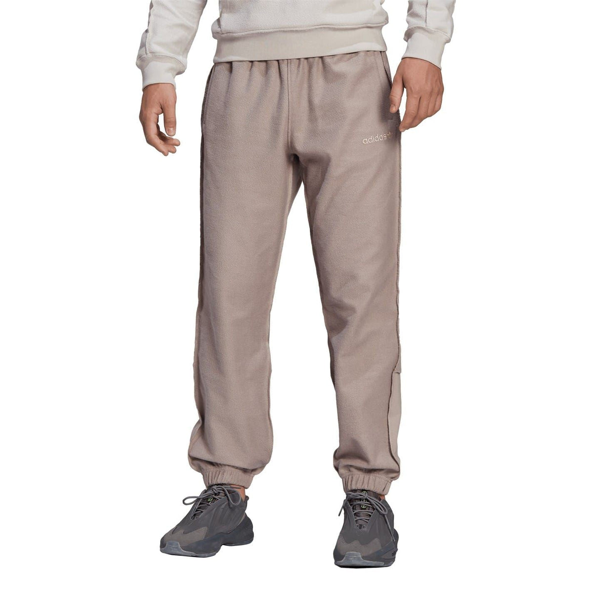 Taupe jogger track pants with elastic waist and drawstring, tapered fit, cuffed hems.