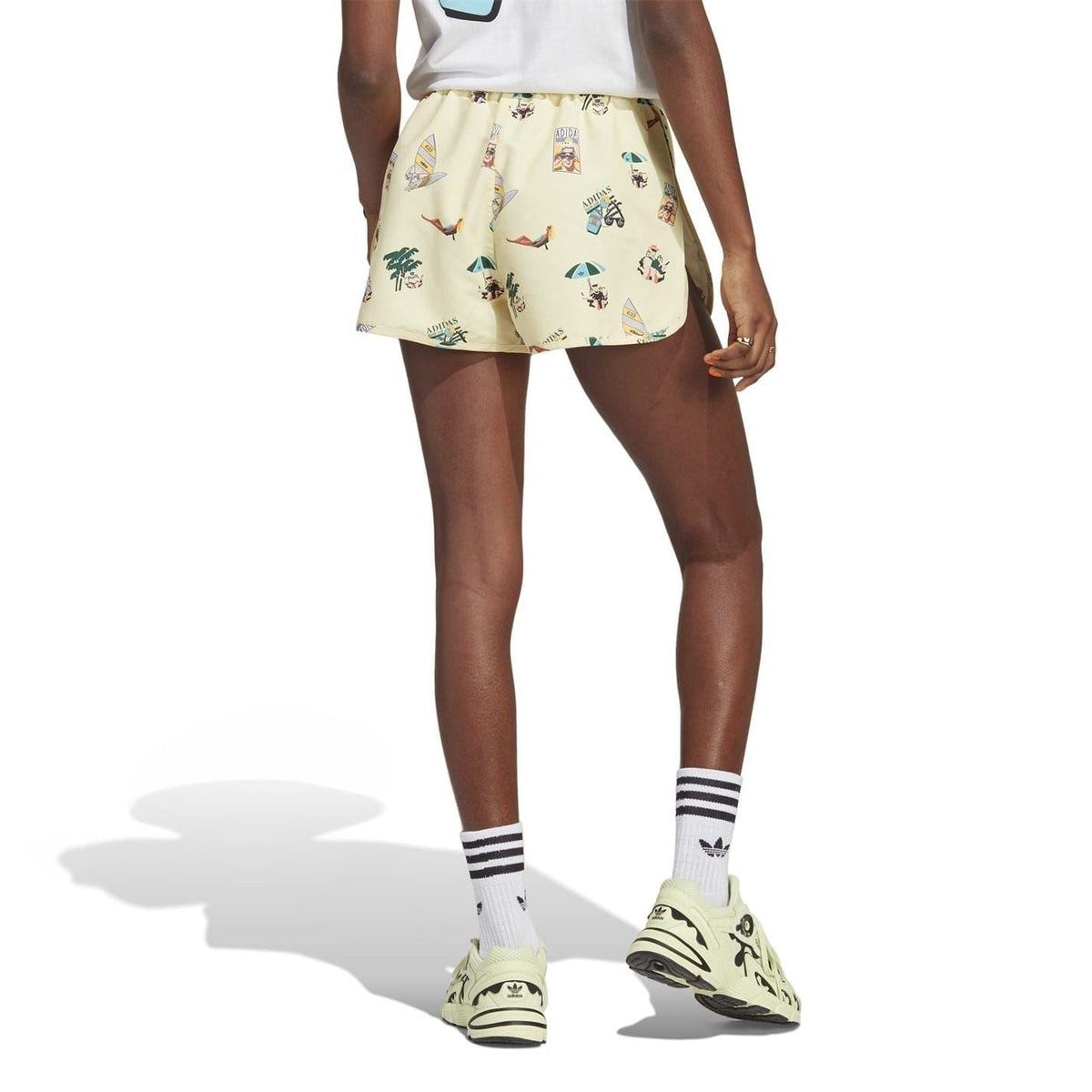 Cream athletic shorts with multicolor comic print and elastic shirred waistband