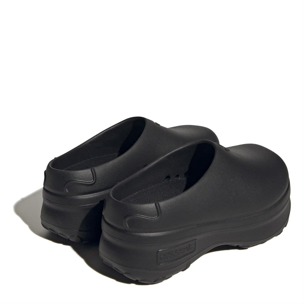 Black low-top trainers with open collar and molded heel details, pair shown from side