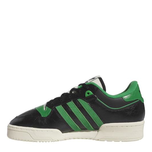 Black and green adidas low-top sneakers with three striped panels and lace-up closure