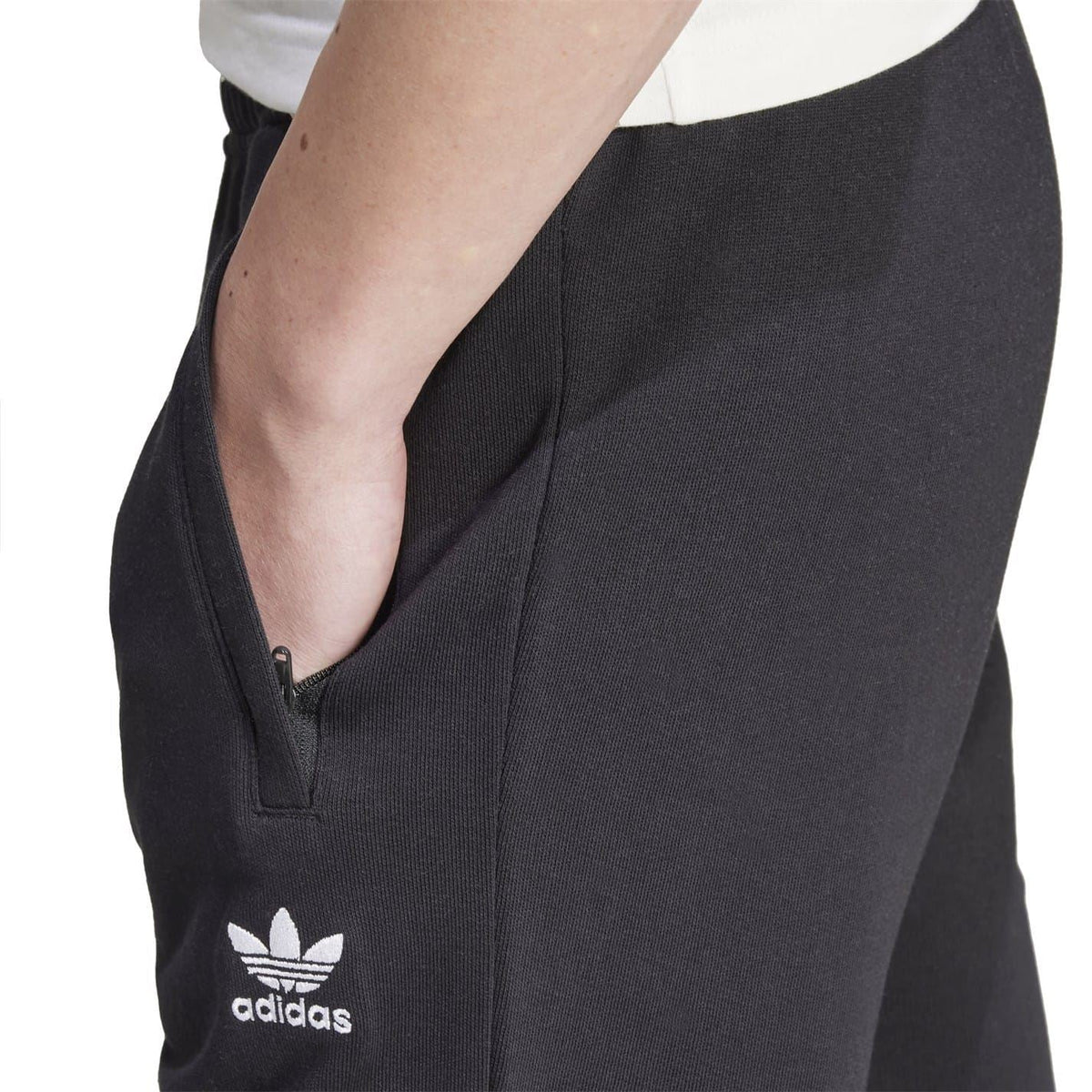 Black joggers with front zip pocket and adidas logo patch on thigh