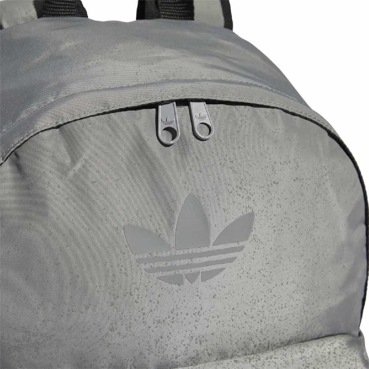 Reflective silver-gray backpack close-up of adidas trefoil logo and top grommets