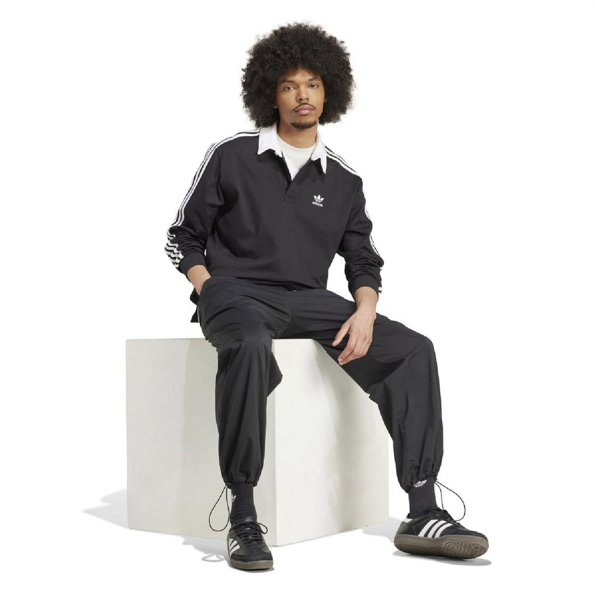 Adidas Originals Adicolor rugby polo shirt in vibrant color with classic collar and short sleeves, displayed on a neutral background.