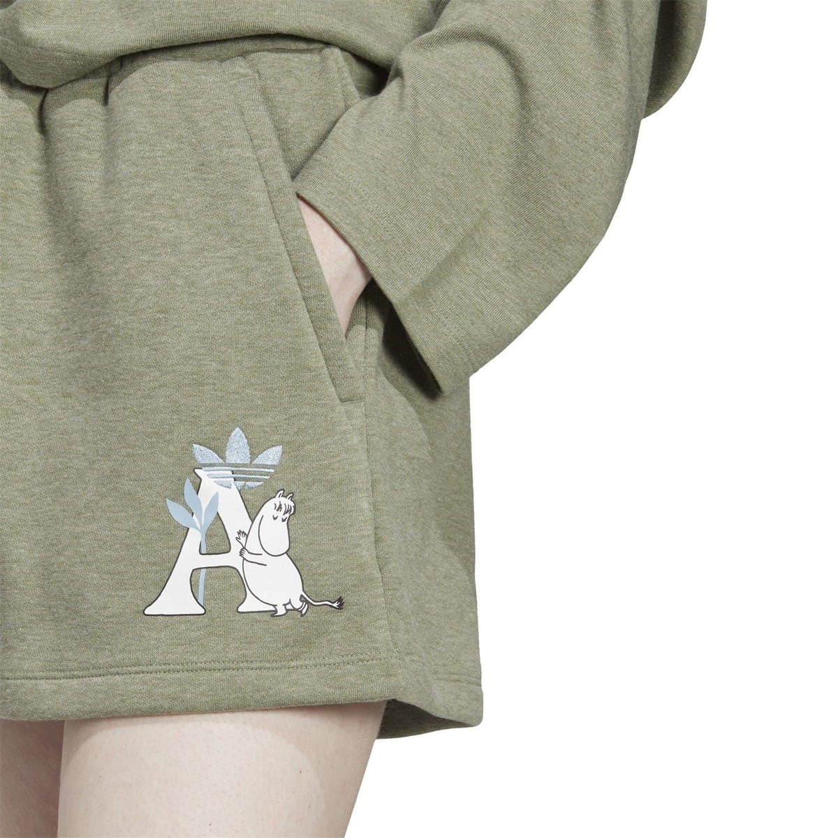 Close-up of green sweat shorts with drawstring and Moomin graphic on the side