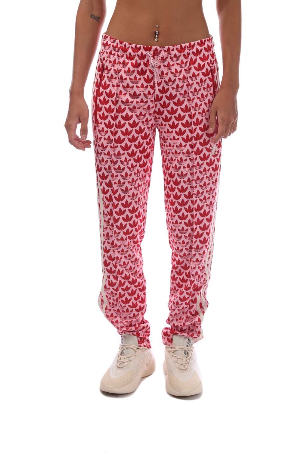 Pink track pants with repeating heart pattern, elastic waistband and ankle cuffs