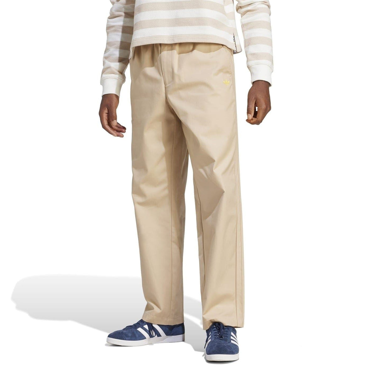 Beige drawstring chinos on model, relaxed straight-leg silhouette with elastic waistband
