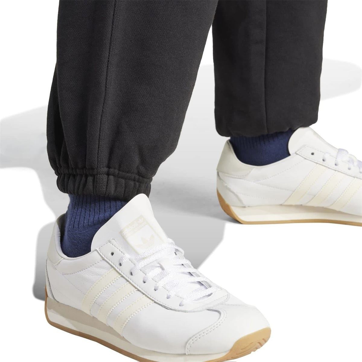 Black adidas Originals joggers hem closeup with gathered cuffs and woven texture