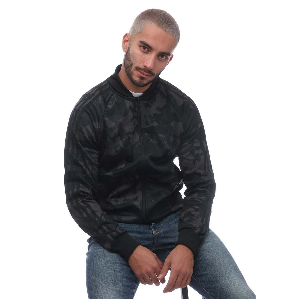Men's adidas track top in black camo, full-zip jacket worn with jeans