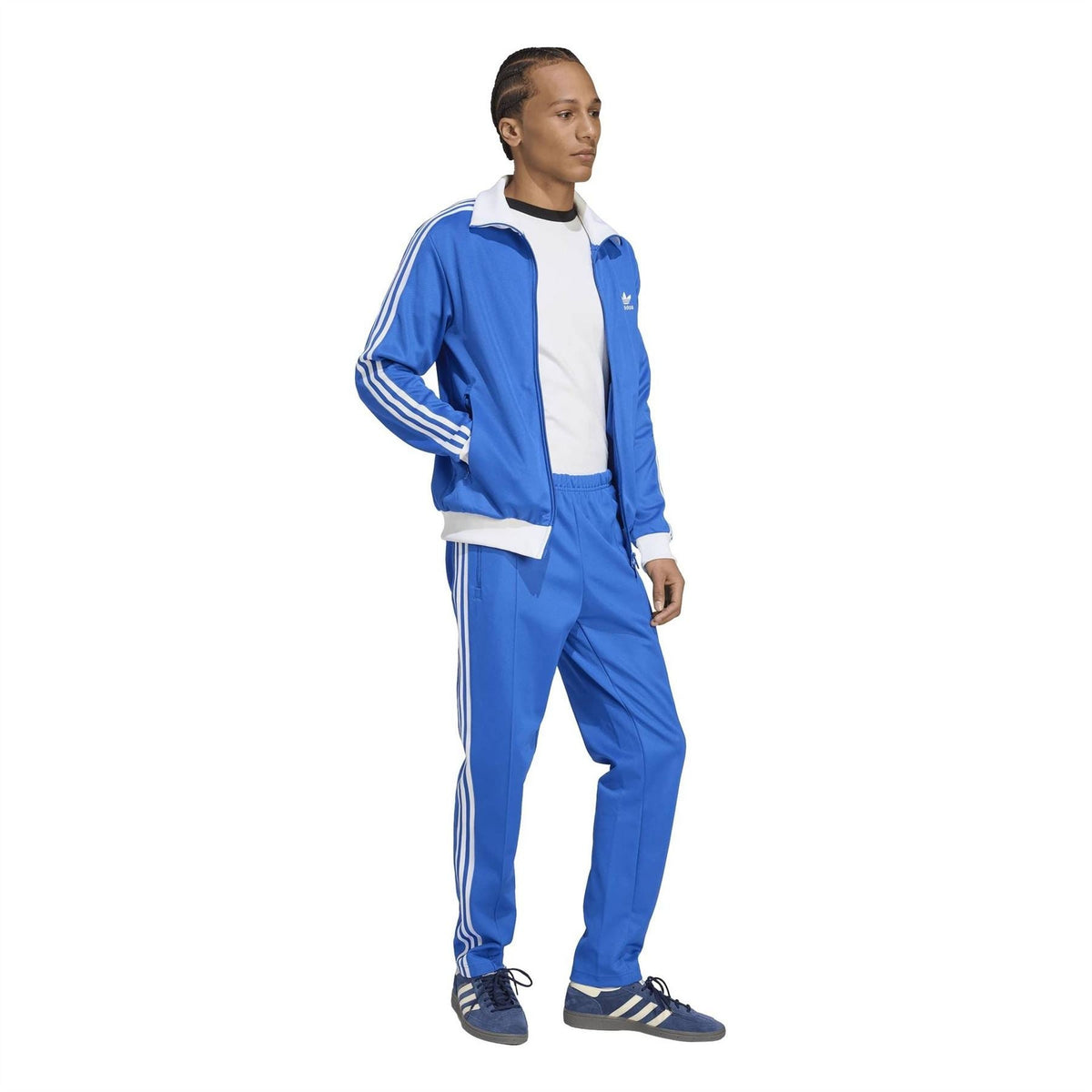 Blue adidas track pants with white side stripes and relaxed tapered silhouette