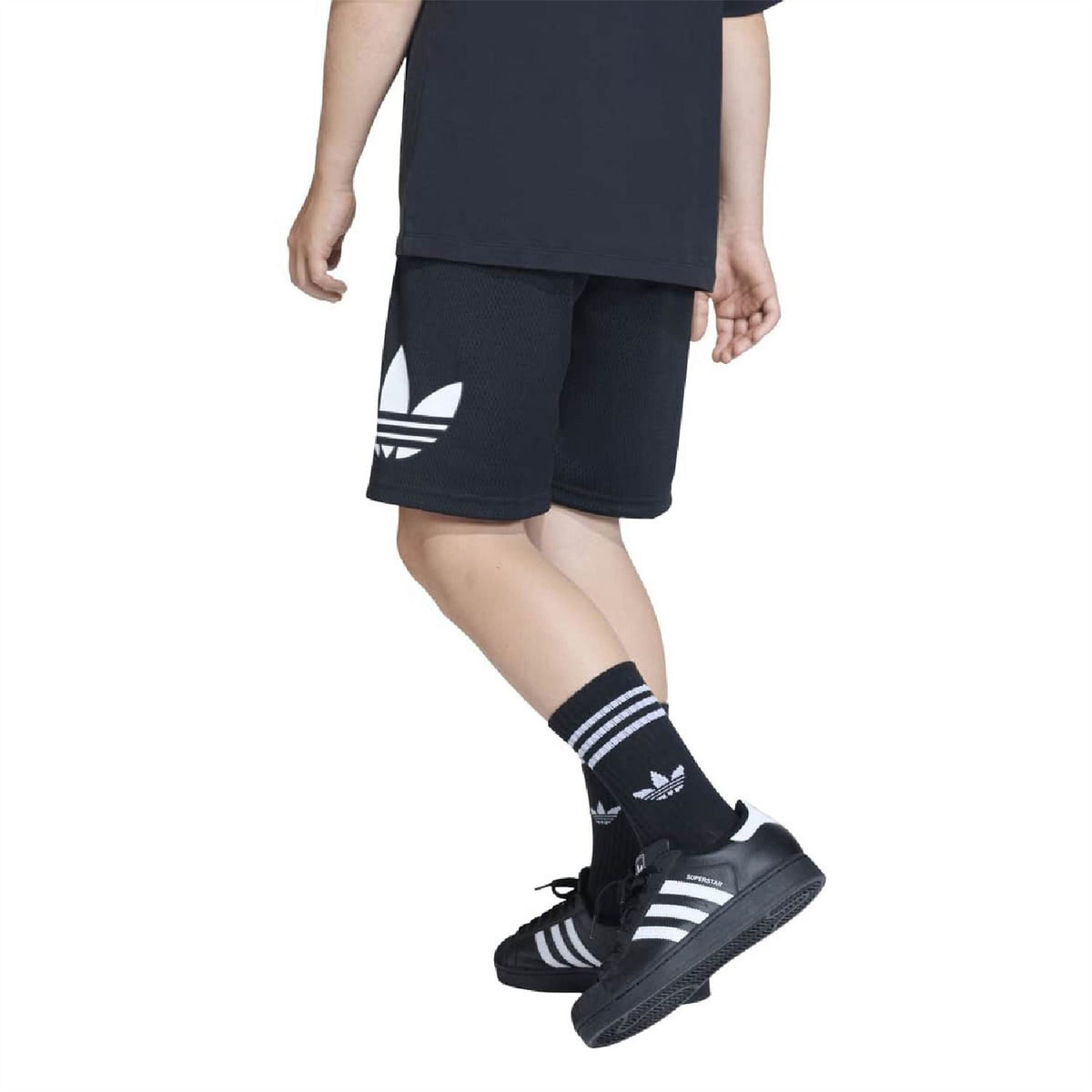Loose black kids' shorts with large side logo, worn with trainers and striped socks
