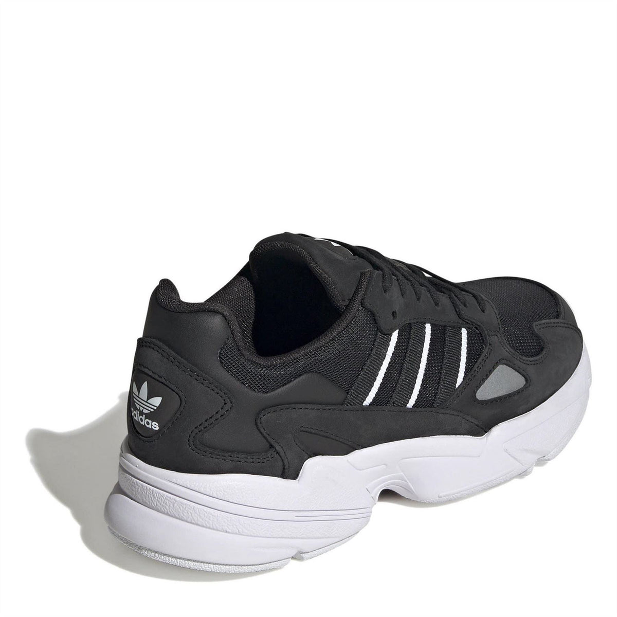 Black low-top lace-up sneakers with white stripes, textured overlays, and white midsole
