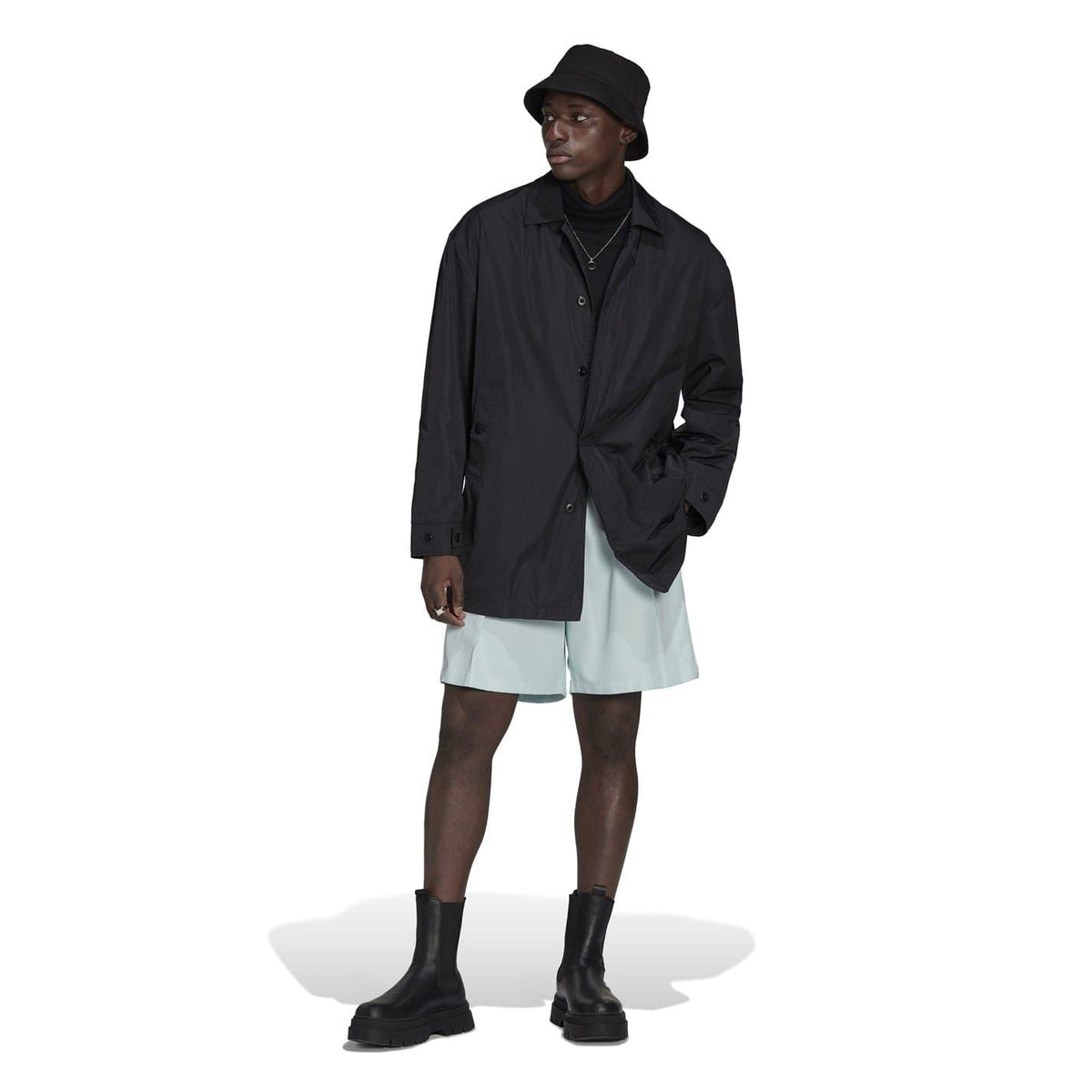 Black men’s button-up jacket worn over shorts with stand collar.