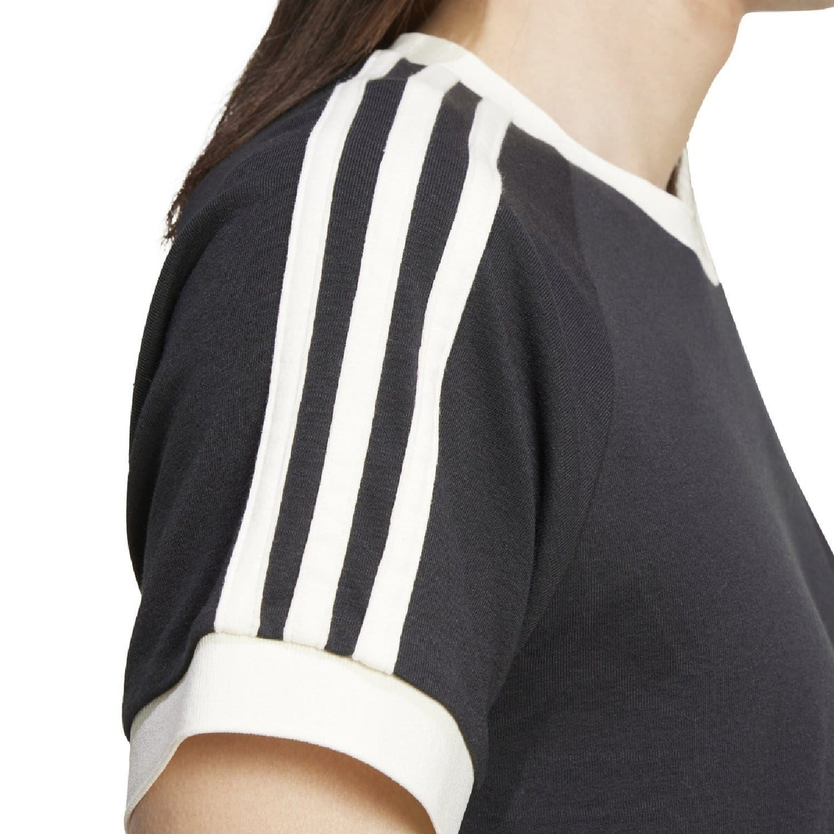 Close-up of black adidas Originals T-shirt with white vertical three-stripe sleeve panel