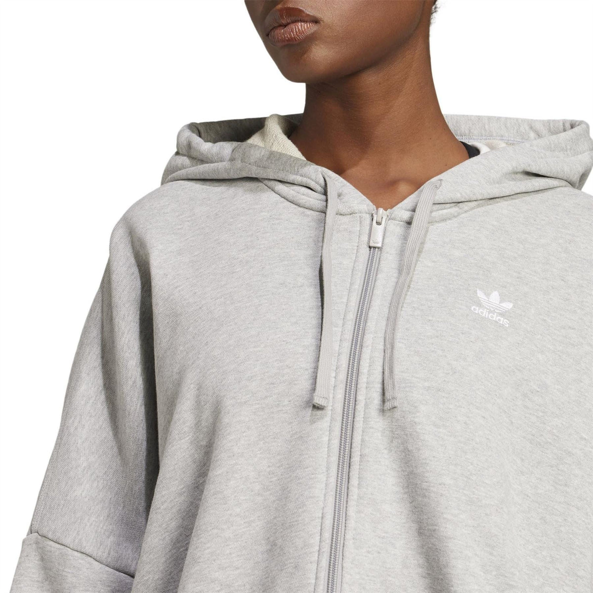 Light grey hooded sweatshirt close-up with front zipper and small chest logo