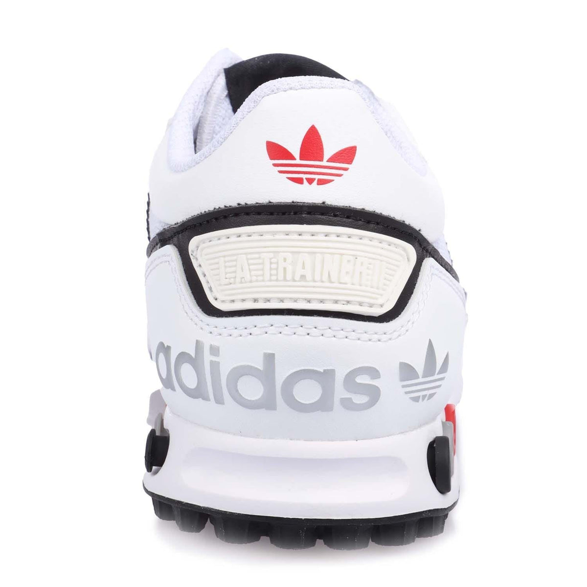 White junior Adidas sneakers with red trefoil heel logo and trainer badge.