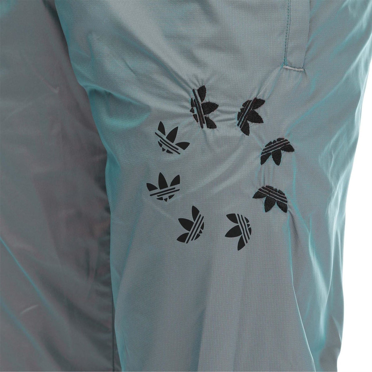 adidas Originals track pants with black trefoil graphic pattern on teal fabric