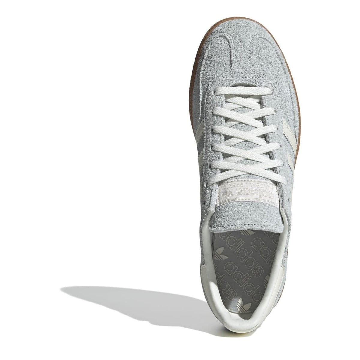 Light gray suede sneaker toe with white laces and rubber cap