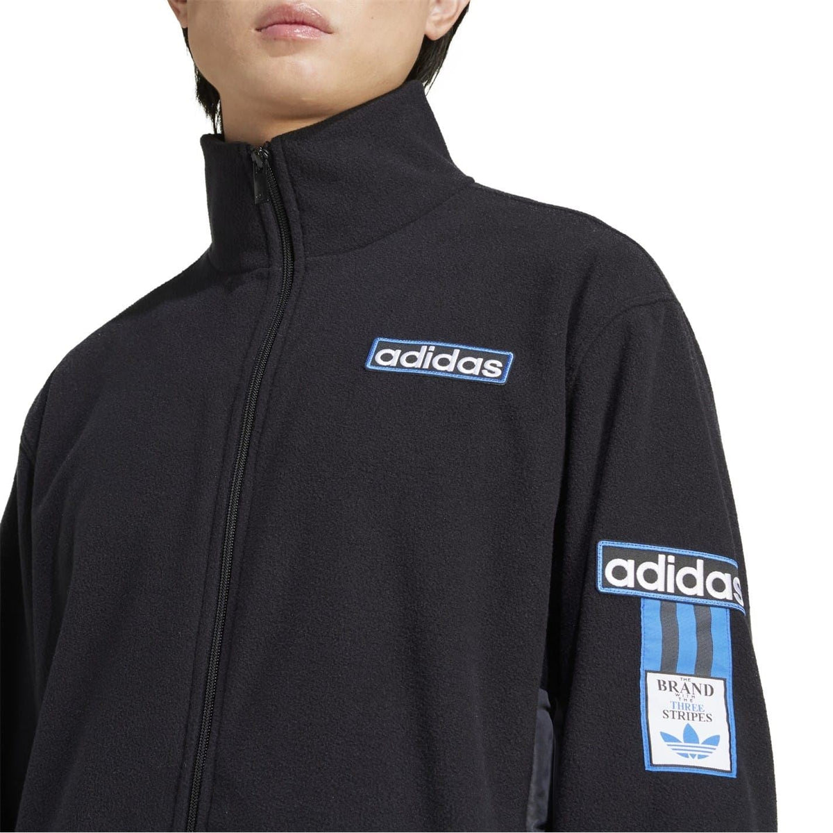 Black adidas funnel-neck zip sweatshirt close-up of chest and sleeve logos