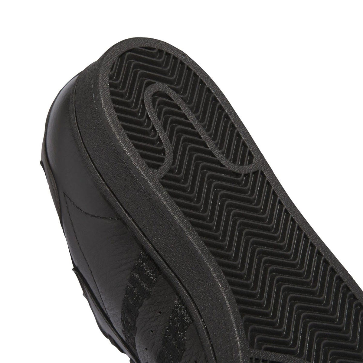 Black rubber outsole close-up with zigzag tread pattern
