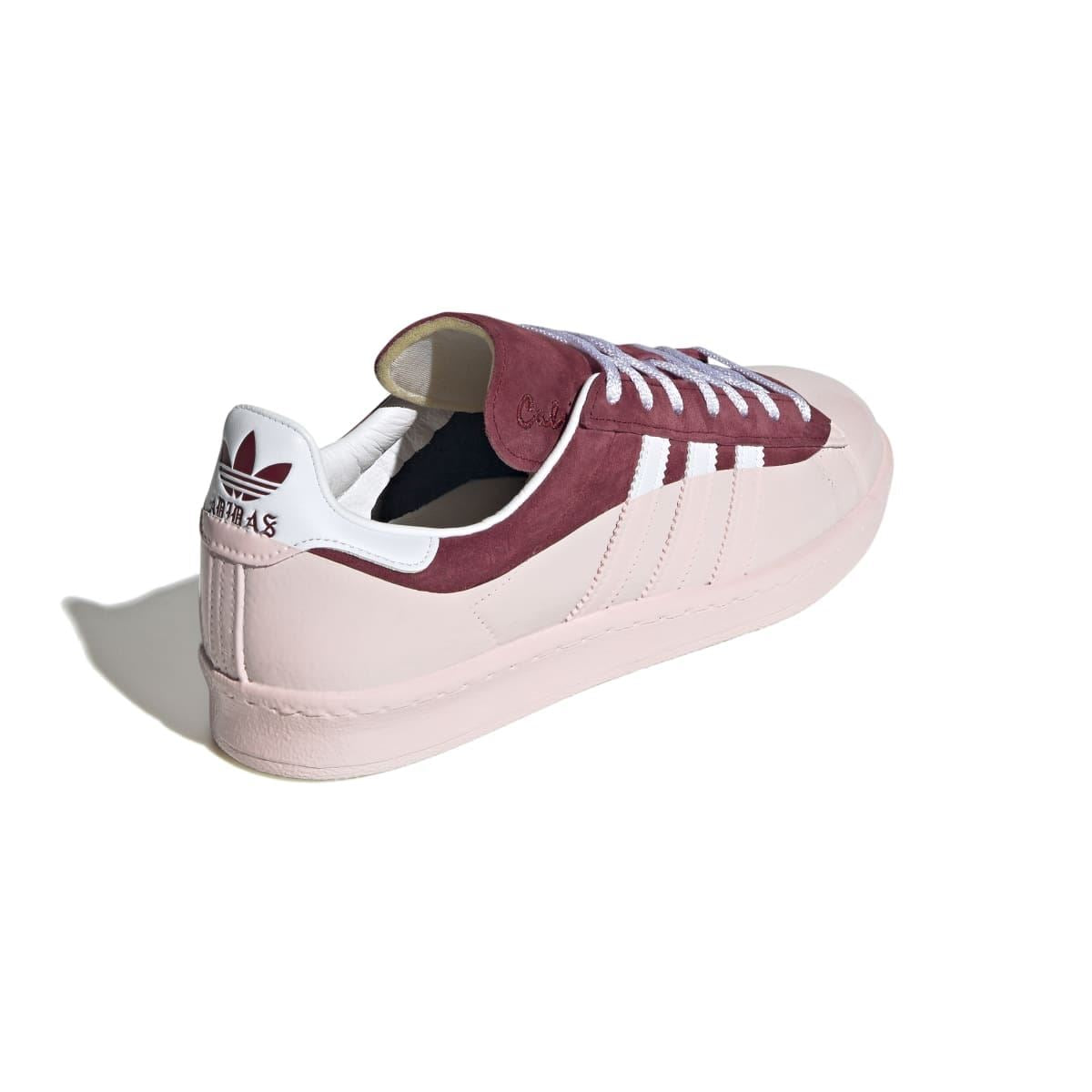 Low-top sneaker with off-white leather upper, burgundy heel panel, and white lace detail