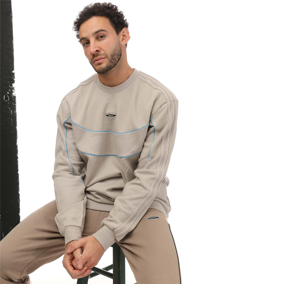 Beige crewneck sweatshirt with blue contrast stripes, adidas logo patch, long sleeves