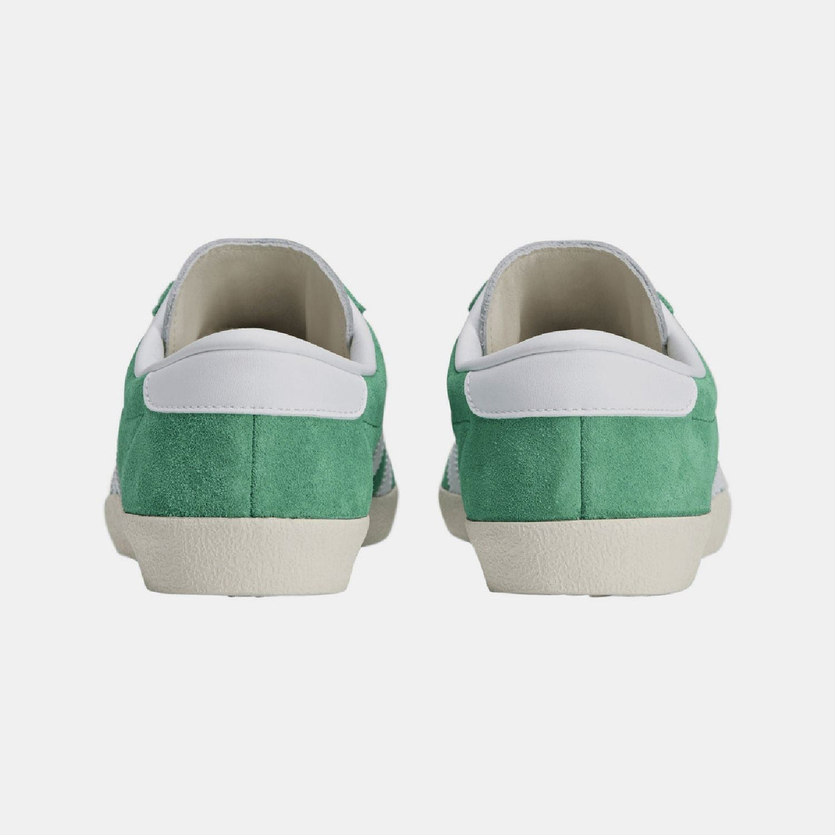 Back view of green suede trainers with white heel tab and cushioned collar.