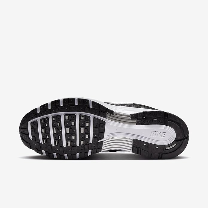 Outsole view of black Nike sneakers with textured rubber tread and white midsole.
