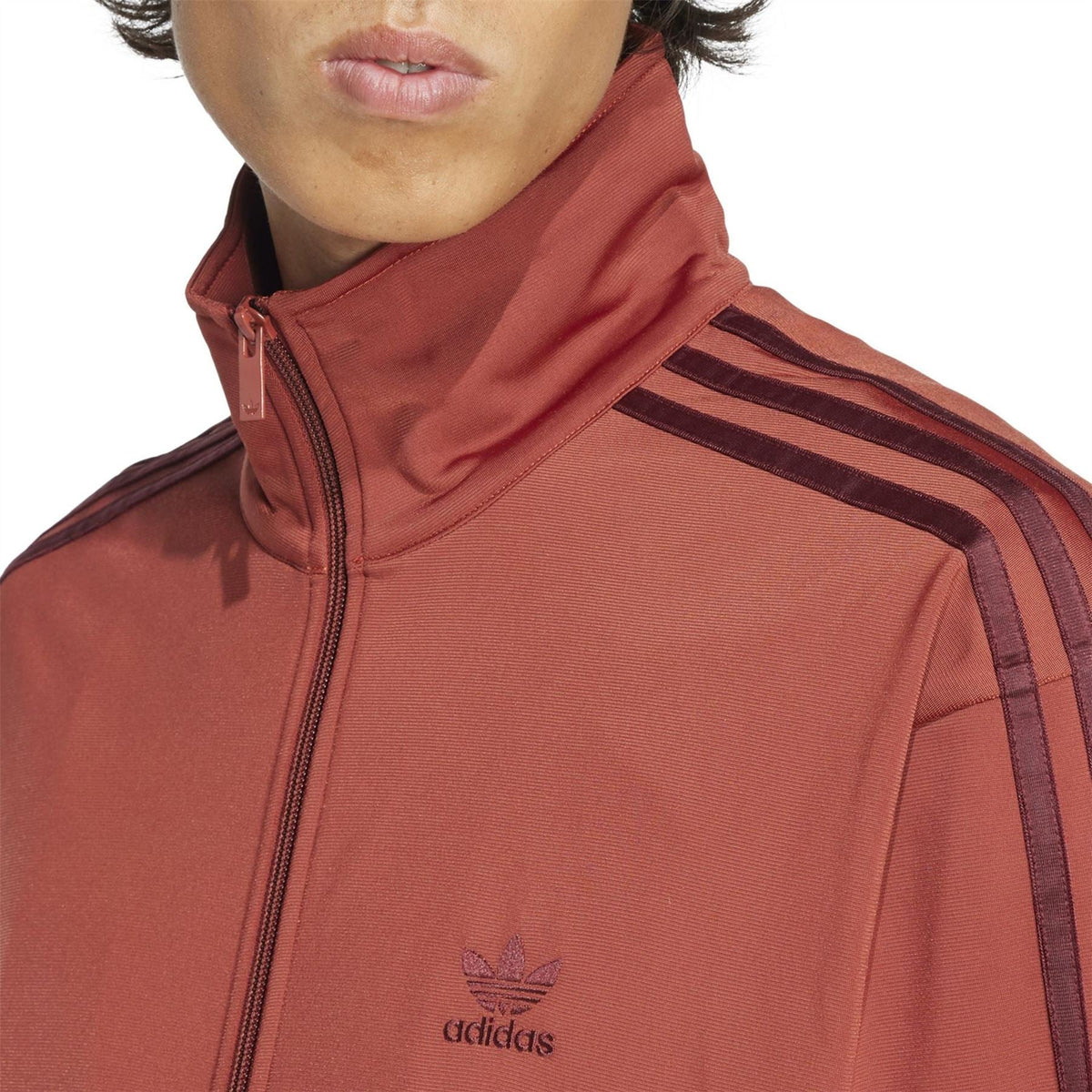 adidas Originals Firebird TT rust red track jacket close-up, adidas logo and zip collar