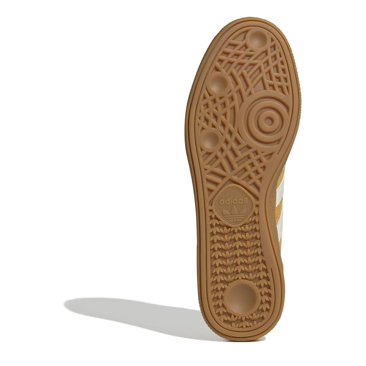 Tan rubber outsole of low top sneakers with traction pattern and adidas logo.