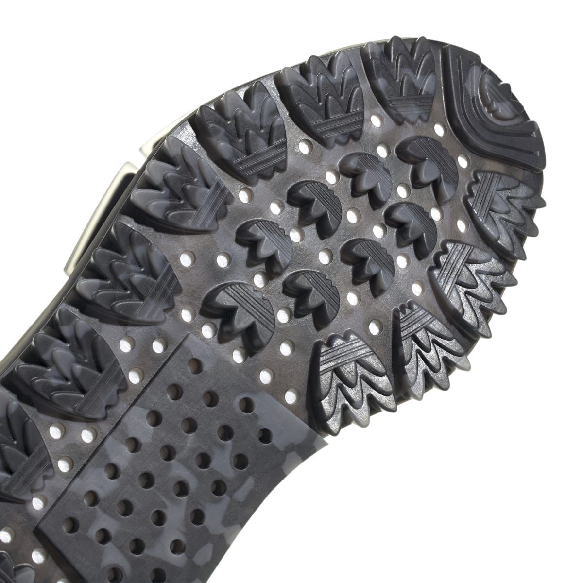 Close-up of black trainer outsole with raised studs and patterned grooves