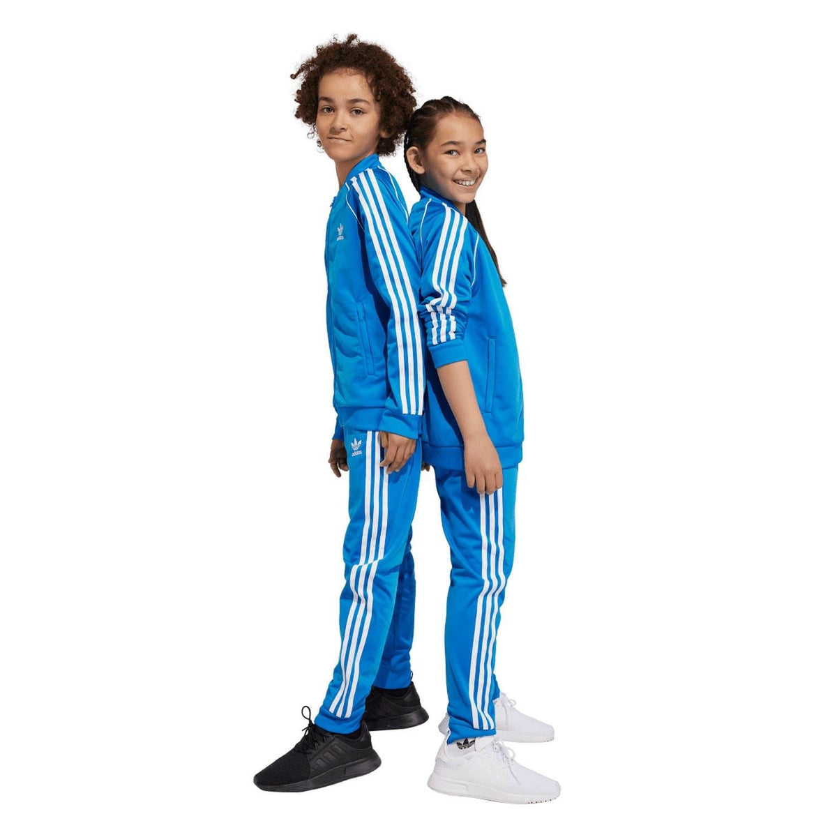 Blue kids track pants with white side stripes and elastic waist, worn by kids