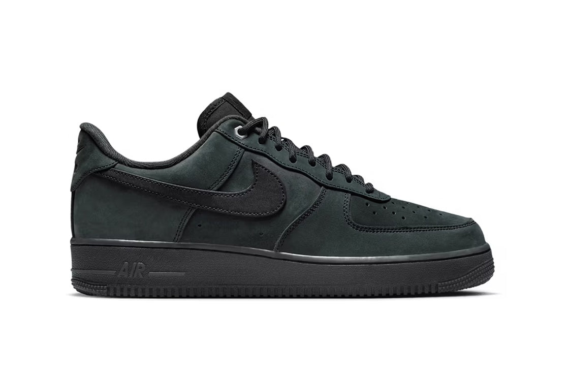 Men's low-top sneakers with dark suede, Nike swoosh, and lace-up front