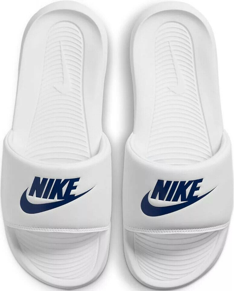 Pair of white Nike slide sandals with NIKE logo and textured footbed tread
