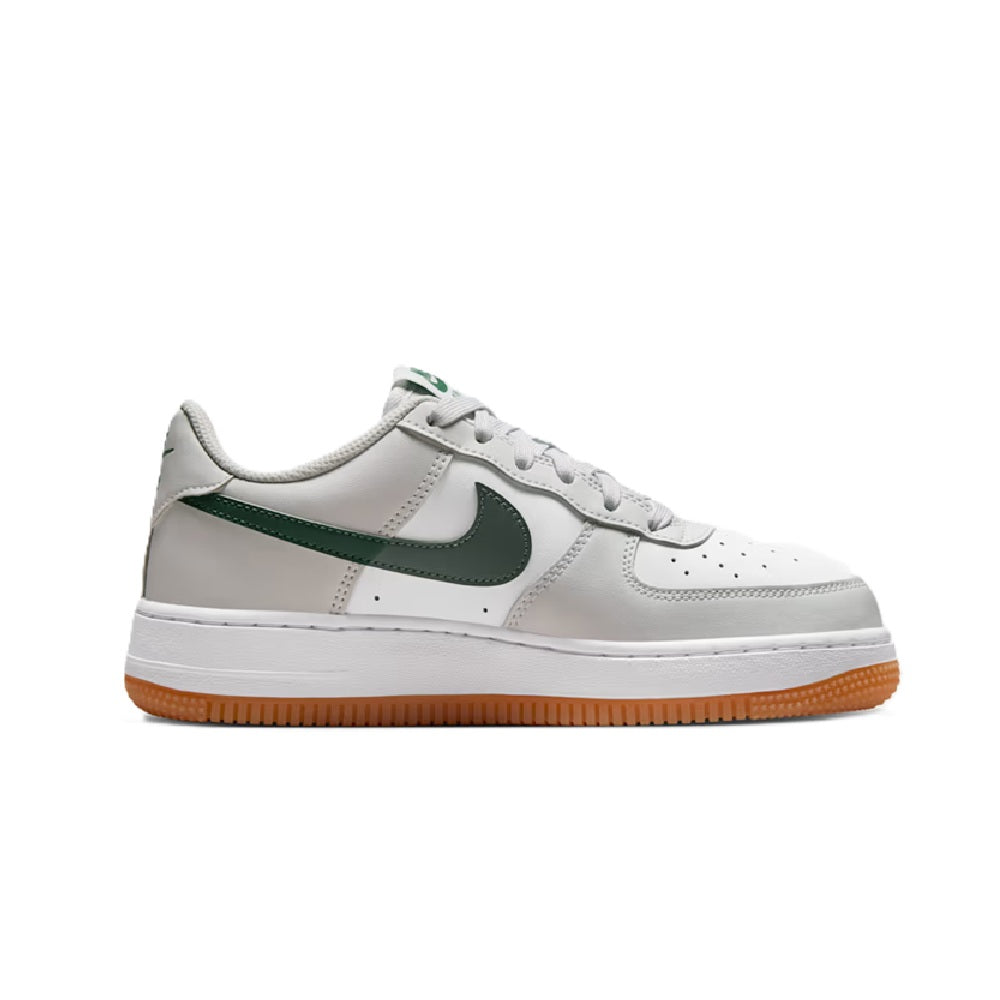 Kids' Nike Air Force 1 sneakers, side view in white with green swoosh and orange gum sole