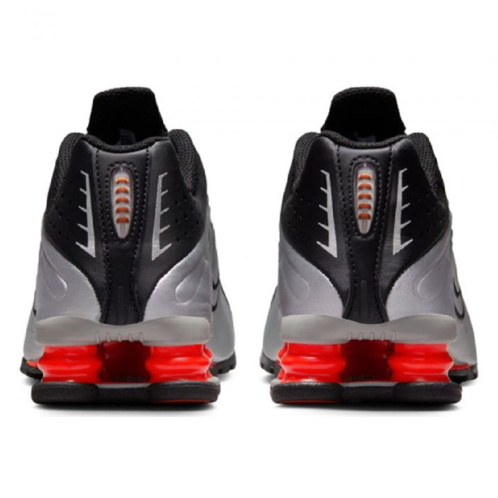 Kids' Nike Shox R4 sneakers heel view, black uppers with metallic silver details, red pods