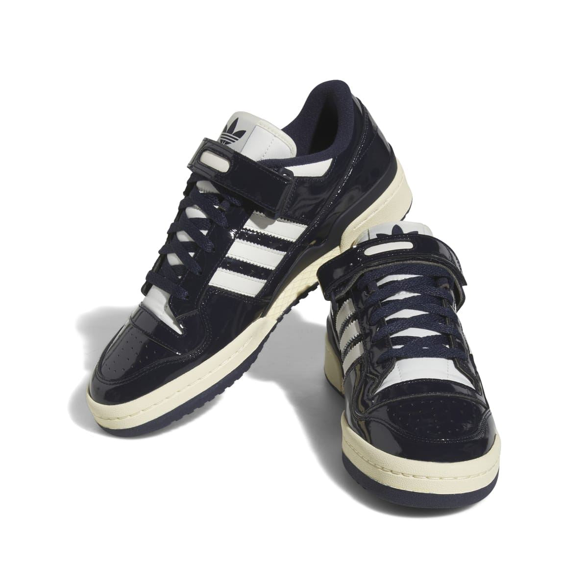 Two-tone view of dark navy adidas low-top trainers with white stripes and off-white midsole