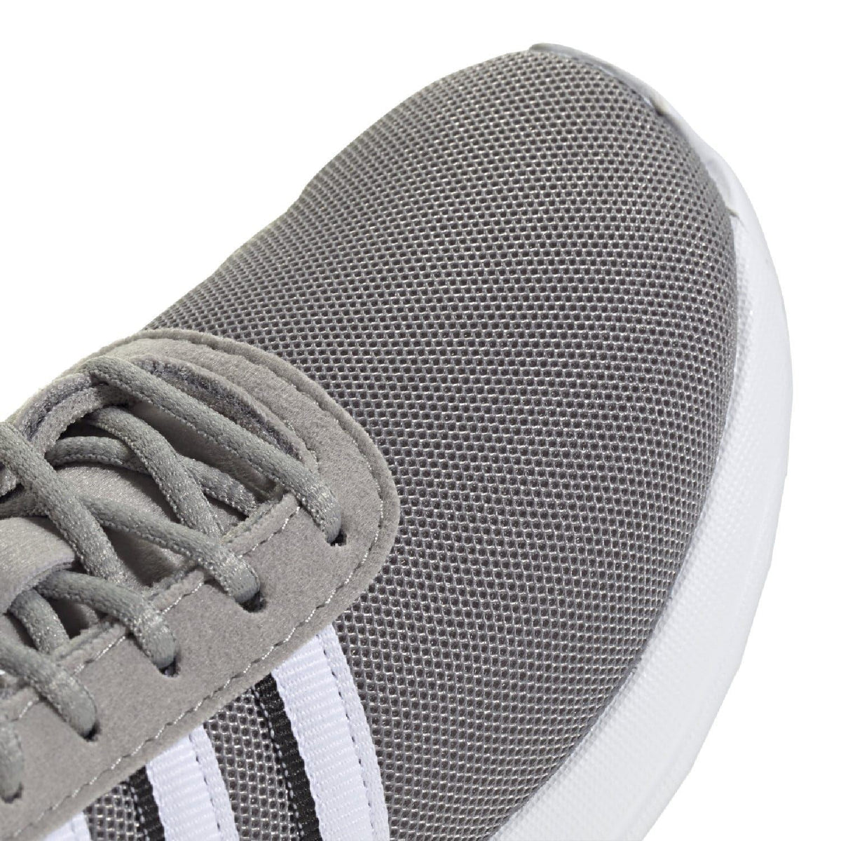 Grey textured mesh upper close-up with lace area and white side stripes