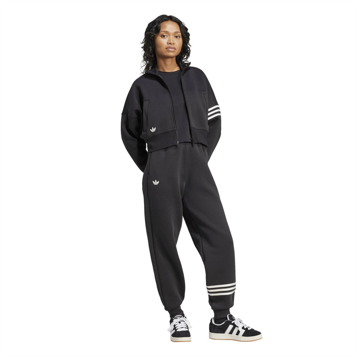 Black adidas track top worn with joggers; striped sleeve band and trefoil logo