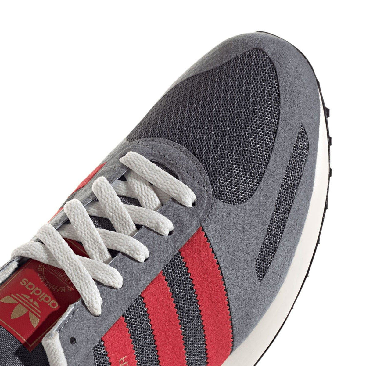 adidas Originals LA Trainers close-up grey upper with red stripes and white lace stitching