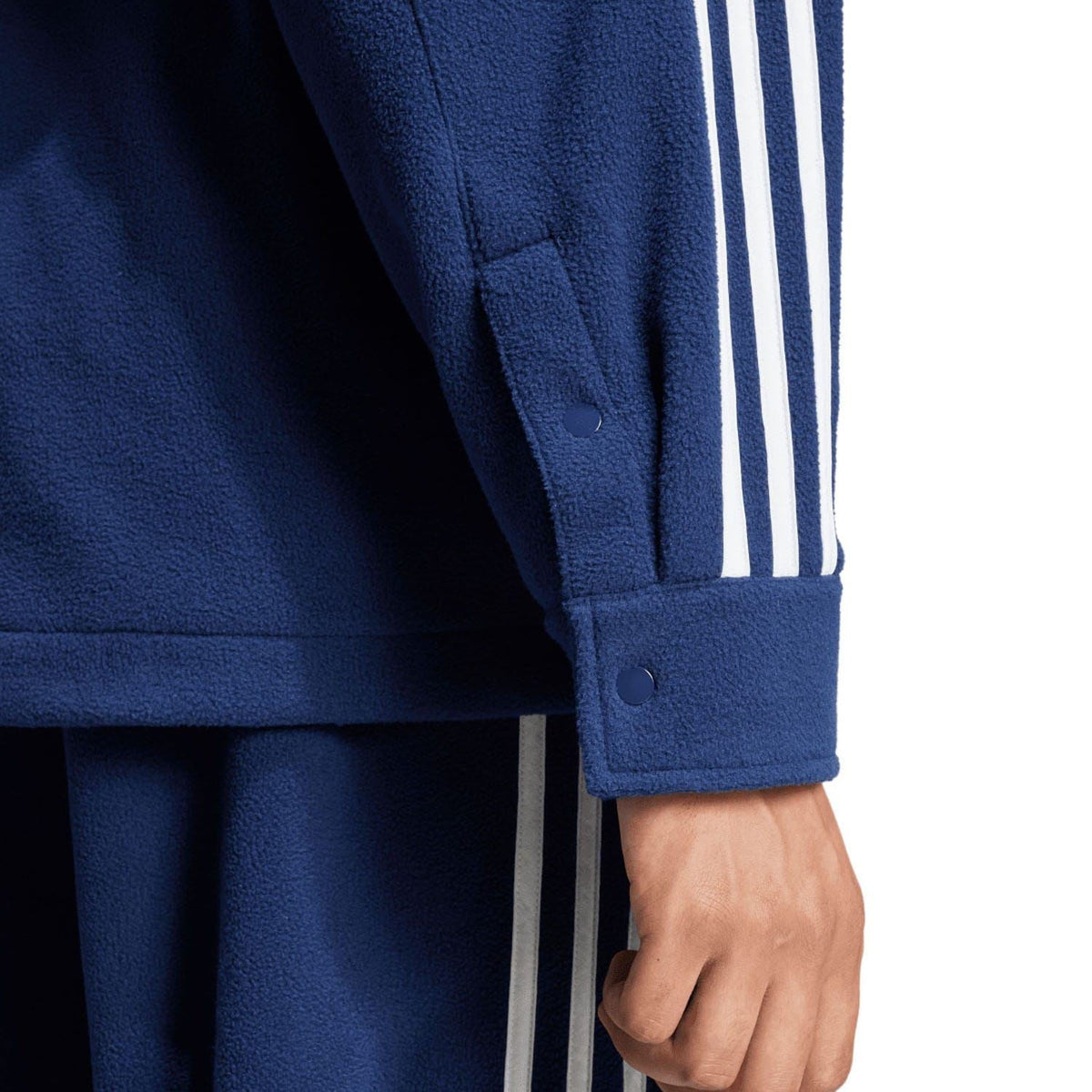 Indigo adidas fleece shirt sleeve cuff with button detail and white three-stripe design