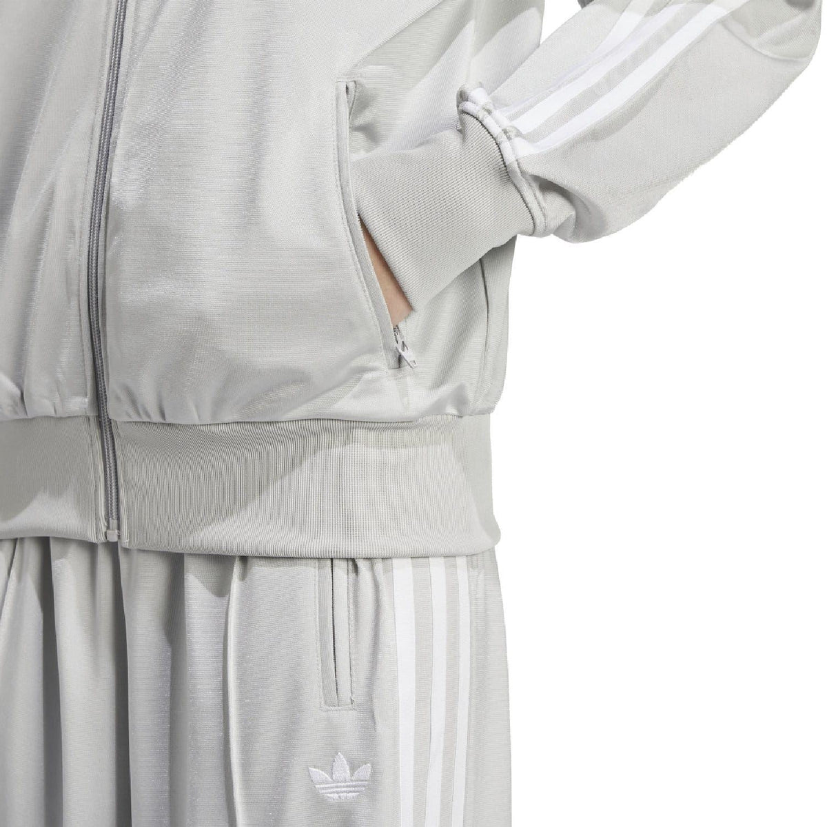 Light grey track jacket hem and cuffs with ribbed texture and trefoil badge