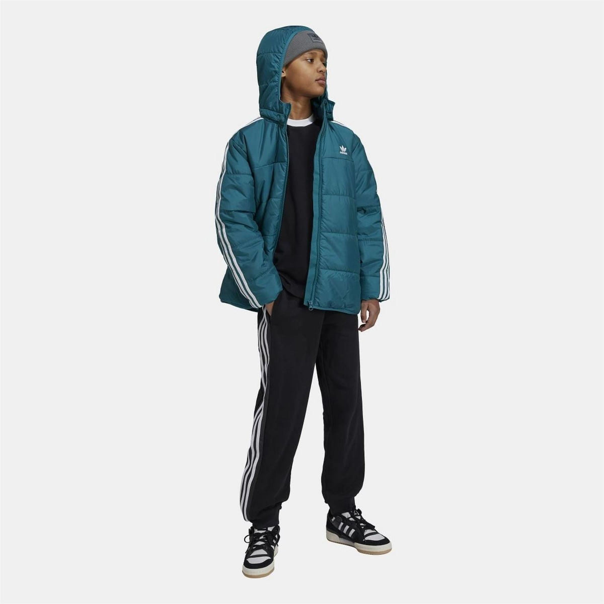 Teal junior padded hooded jacket with full zip, white side stripes, over black pants