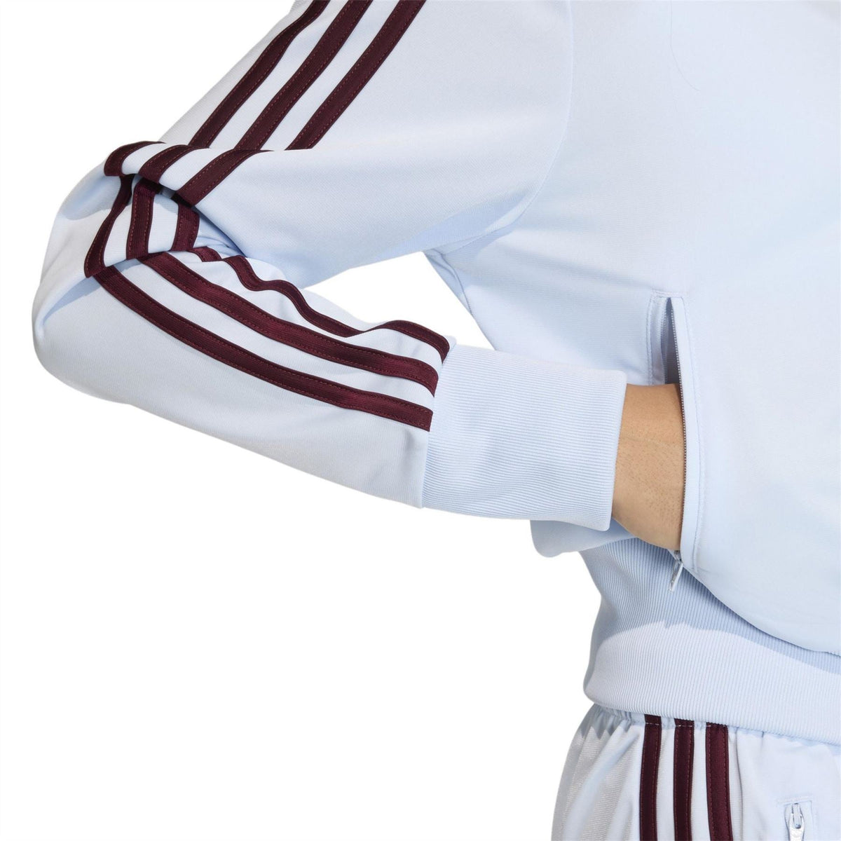 Light blue women’s track jacket sleeve with burgundy triple stripe and elastic cuff.