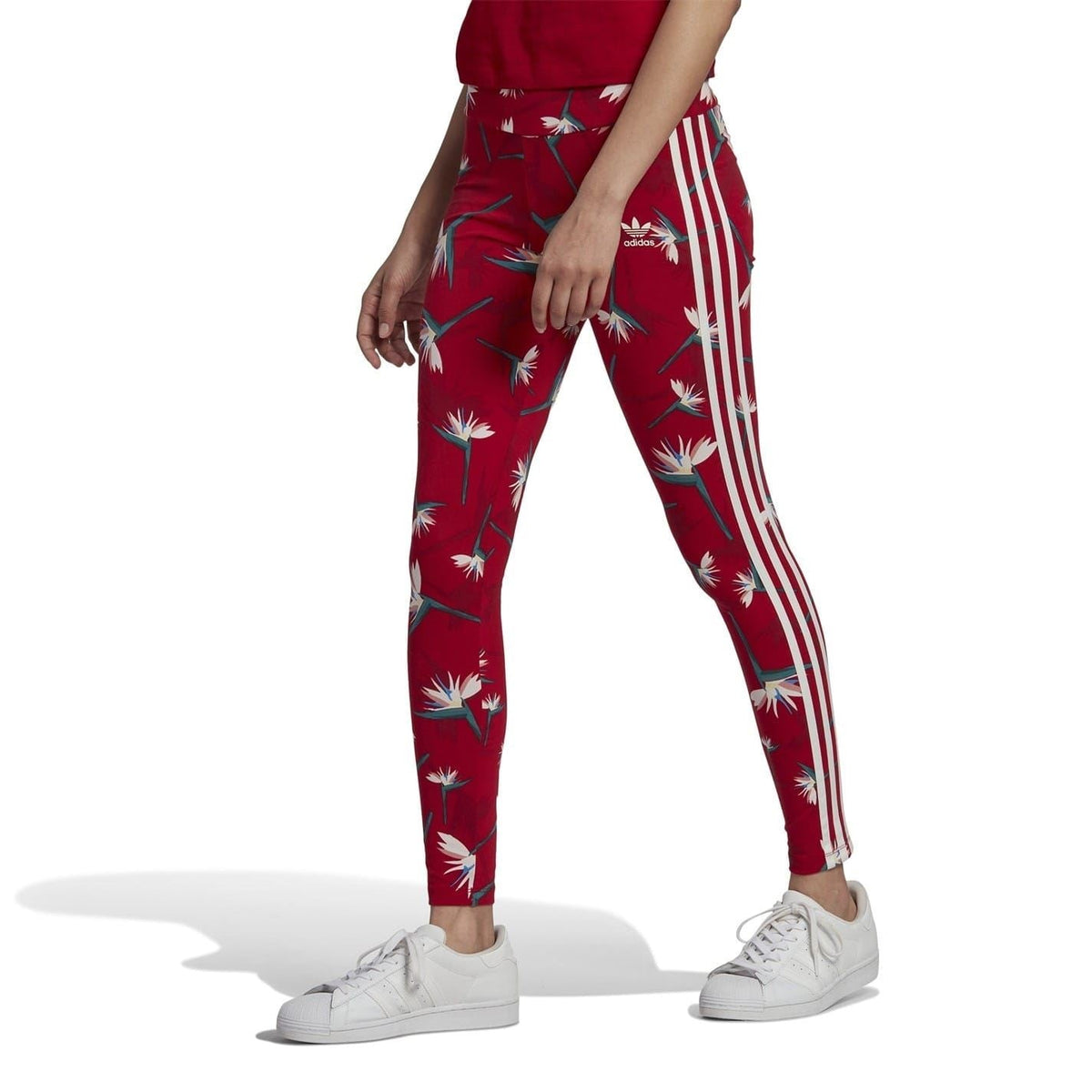 Red tropical-print adidas leggings with white side stripes, ankle-length fit