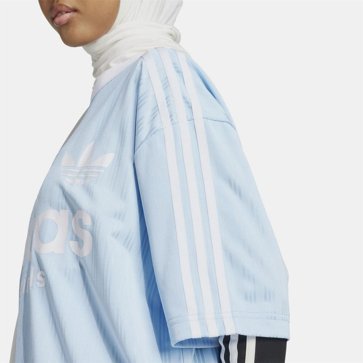 Light blue adidas Originals T-shirt sleeve detail with vertical stripes and trefoil
