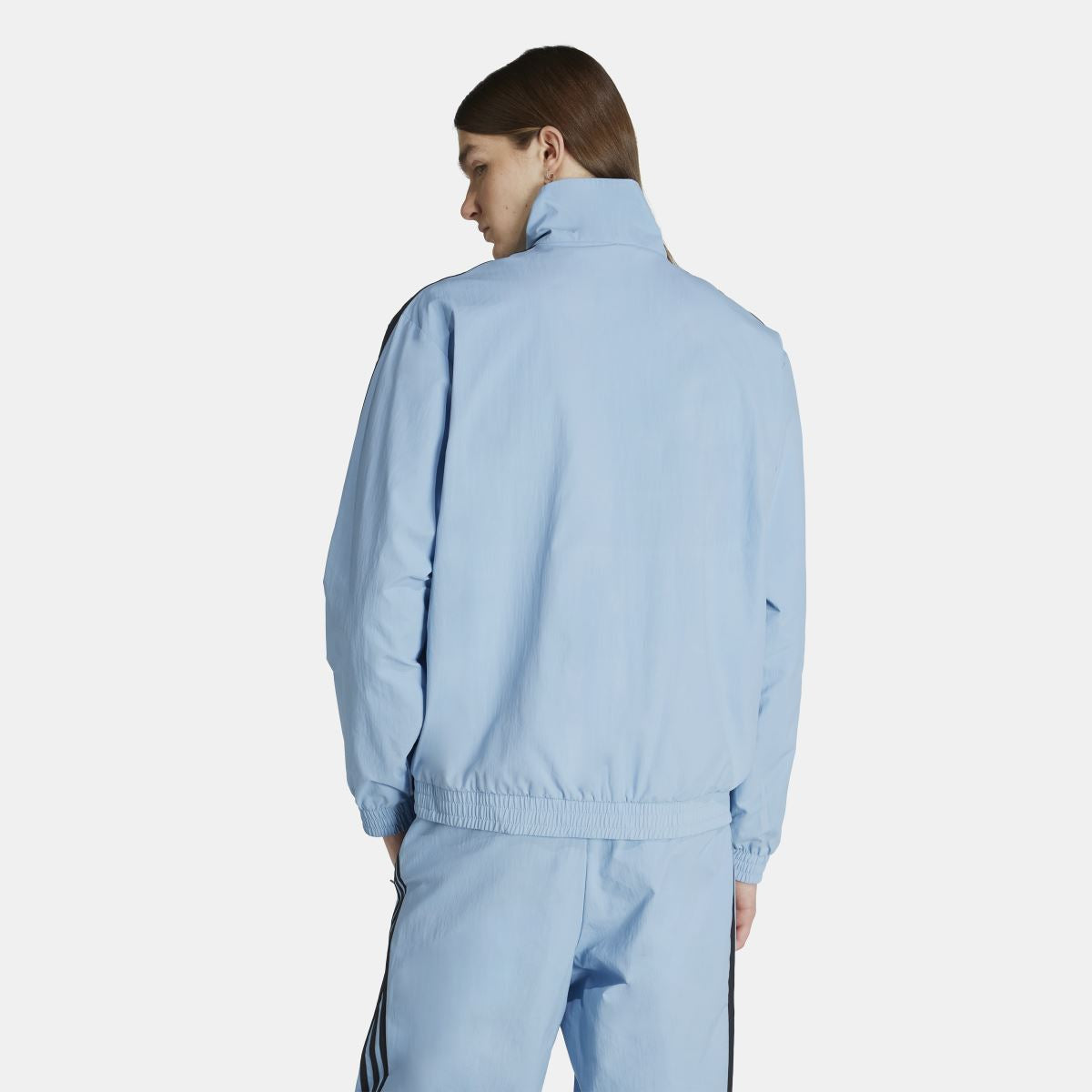 Light blue woven track jacket back view with stand collar and elastic waist hem
