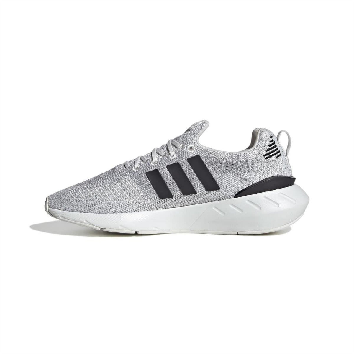 Grey adidas trainers with three black stripes, lace-up front, and white cushioned sole.