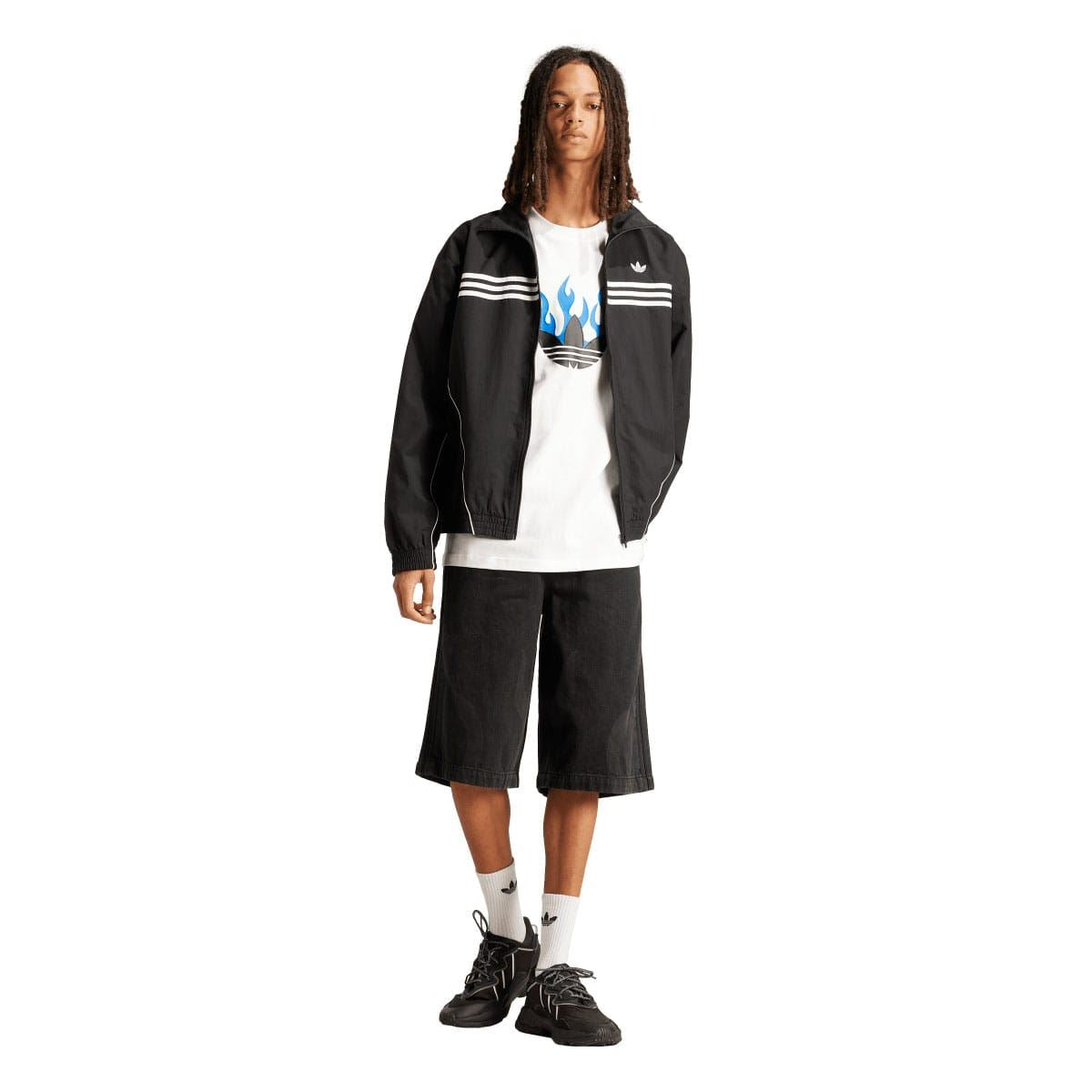White crewneck T-shirt with blue flame trefoil graphic under dark jacket