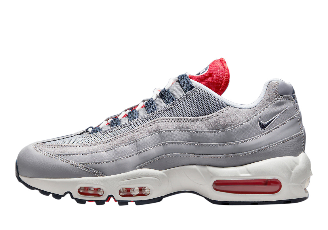 Men's Nike Air Max 95 in cement grey with red and blue accents, lace-up running shoes.